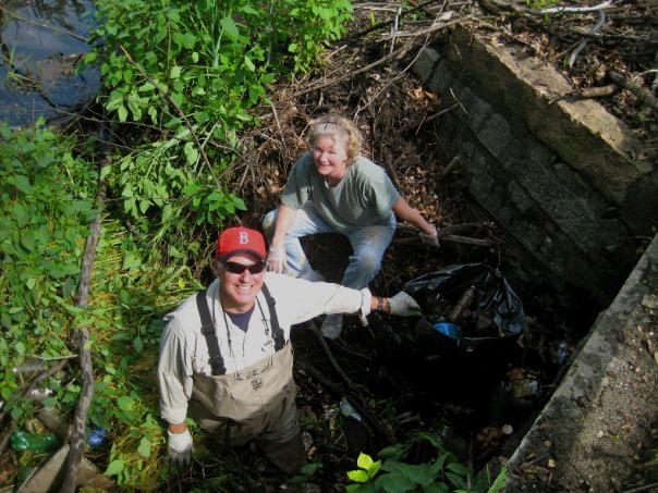 Pat Conway and Betsy Brigham pull trash out of the Beaver Dam at Settling Ponds. (Courtesy of Tom Antonellis)