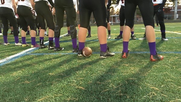 Pictured above is the Wayland football team warming up for their game against Bedford. The team is wearing purple socks during the month of October to raise awareness for domestic violence. 