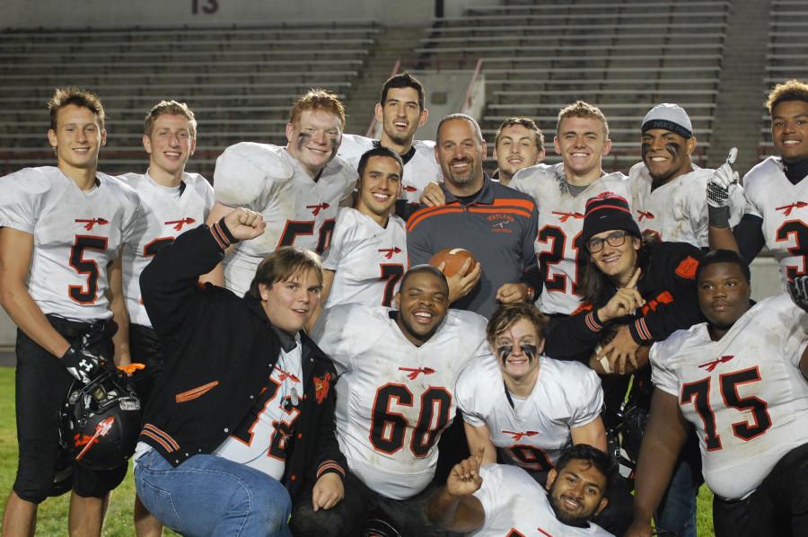 Pictured above is head coach Scott Parseghian with his players. The Warriors' win against Boston Latin on Friday marked Parseghian's 100th win at Wayland. 