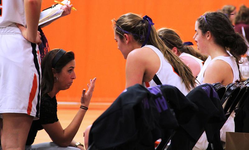 Pictured above is Amanda Cosenza, the girls basketball coach, talking to the team during a time out.  Practice players from the Intramural Basketball League, IBL, have recently began to help the team practice.