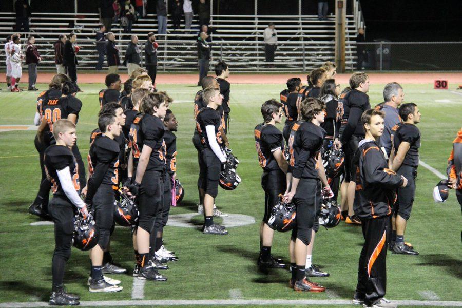 Pictured above is the Wayland varsity football team standing for the National Anthem before a game two years ago. Four students chose to kneel during the anthem this season. 