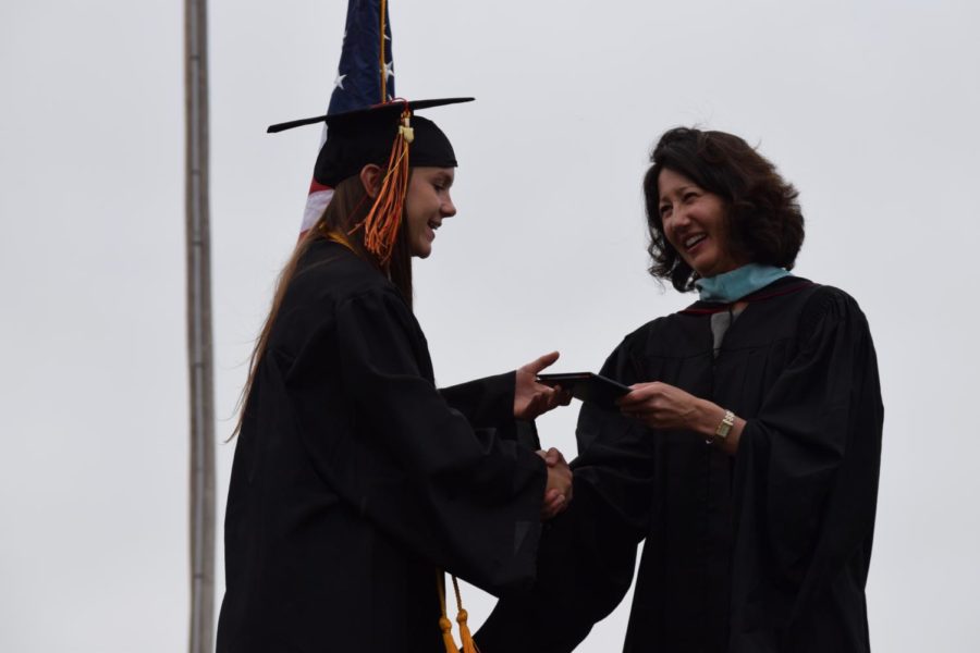 Mizoguchi hands a diploma to graduate Emma Blahut at the Class of 2017 graduation.