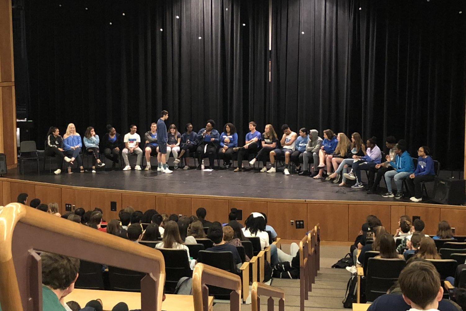 Students in the panel sit on stage.