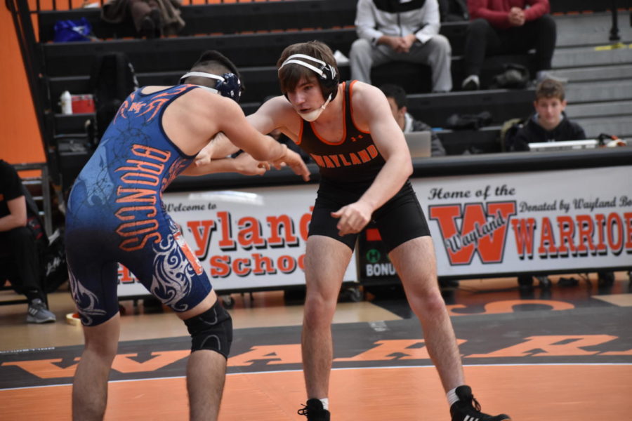 Junior Erik Swanke extends his arms as he prepares to take down his opponent from Keefe Tech. 