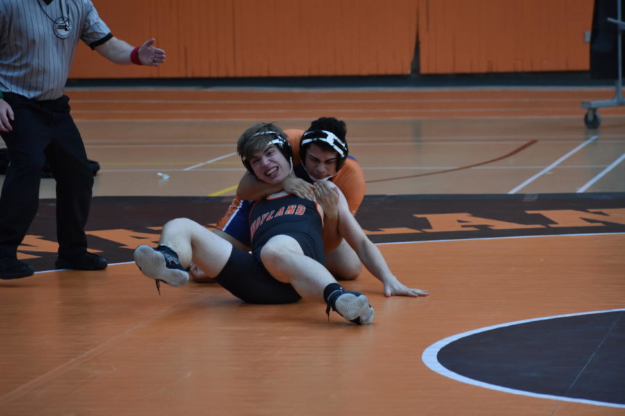 Sophomore Luke Stithams' neck is held in a headlock by Keefe Tech wrestler. Stitham is returning to the team for his second season. “[The] most challenging part was probably the matches themselves [and] trying not to get pinned,” Stitham said.