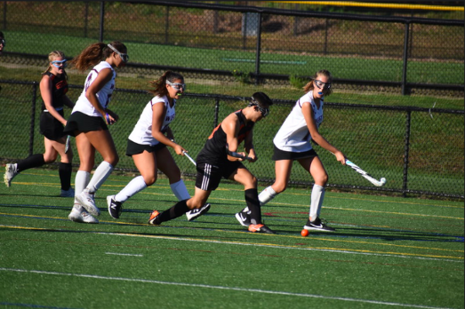 Forward senior Zeke Betancourt hits the ball away from Weston's defenders. The field hockey team has had a break through season as they enter the playoffs. "We all just push each other to be our best selves on and off the field," team member junior Emmie O'Shaughnessy said.  
