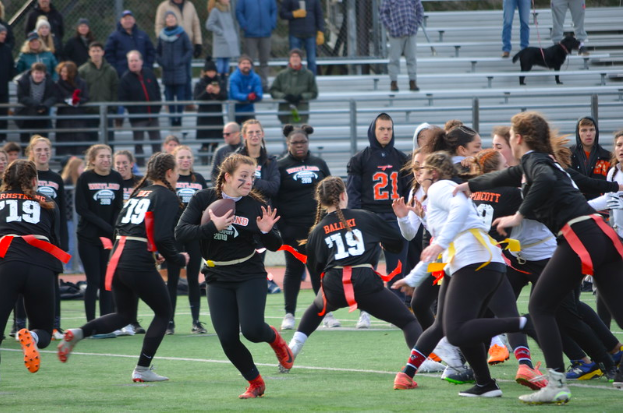 Wayland graduate Abby Mitty runs the football down the field in the 2018 Wayland vs. Weston powderpuff game. Wayland hopes to keep up its longstanding winning streak. “This experience is a very fun thing for girls to do,” senior Kayla Poulsen said.
