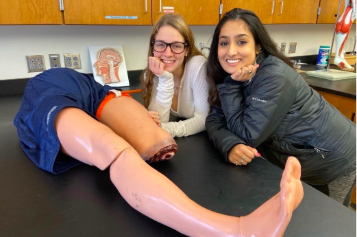 Seniors Mallory Leonard and Sarina Patel work with dummy thighs and learn how to efficiently stop bleeding. 