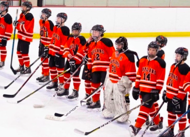 Last years WHS boys hockey team lines up for the national anthem before a game. This year, the team is preparing for the season with two new goalies. [A goalie] is one of the most important positions, Bonner said. It is the last defense before the goal.