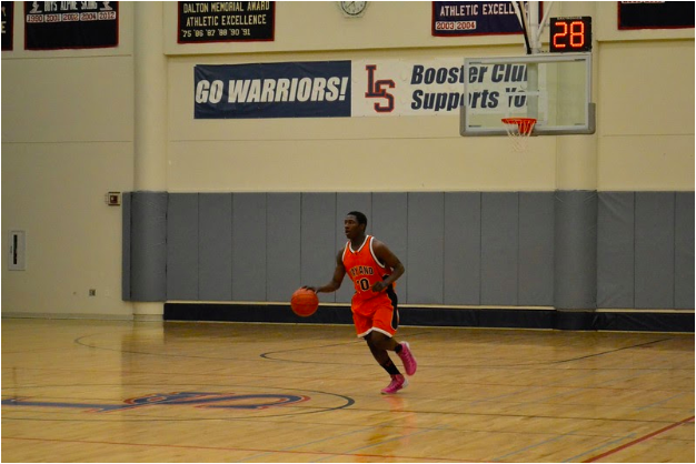 Former Wayland Varsity Basketball player Robert Williams dribbles down the court setting his team up for the next play. After graduating from Wayland High School, Williams has come back to coach the freshman basketball team. “Im very excited to be back in town with the opportunity to coach,” Williams said.
