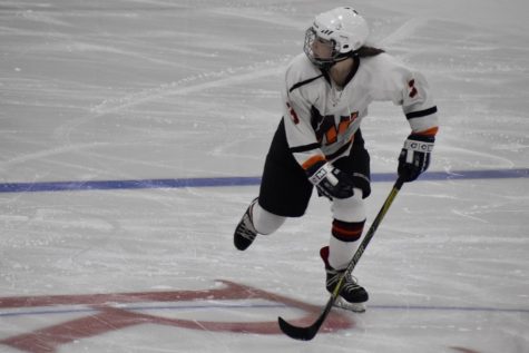 Wayland sophomore Julia Wegerbauer skates down the rink towards Wayland's goal and looks to her teammate for a pass.