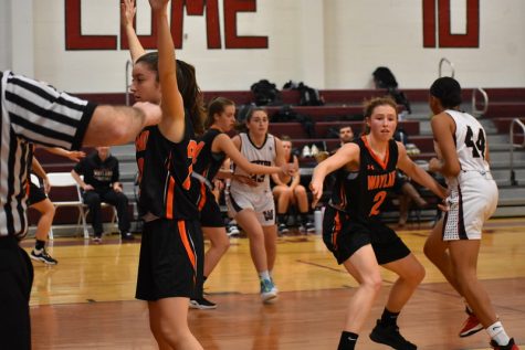 Seniors Isabella Arenas, Emma Kiernan, and Laura Foley guard Weston players, trying to prevent them from getting the ball and shooting.