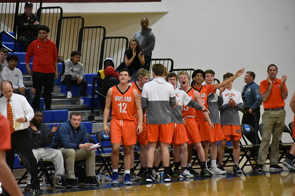 The team jumps to their feet and cheer as they score a basket, bringing the score closer. Throughout the season, the boys never failed to have enough energy from the bench.