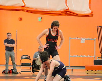 Senior Emma Sheehan towers over her opponent from Tri-County as they prepare to continue the match. This would result in one of many wins achieved as she headed towards All-States. “It was definitely the right decision because I now get to say that I am the first girl on the wall at Wayland High School,” Sheehan said.