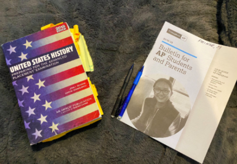 Two AP books and pencils lie on a student's bed. This year's AP tests are being moved to online and shortened to 45 minutes due to Coronavirus.