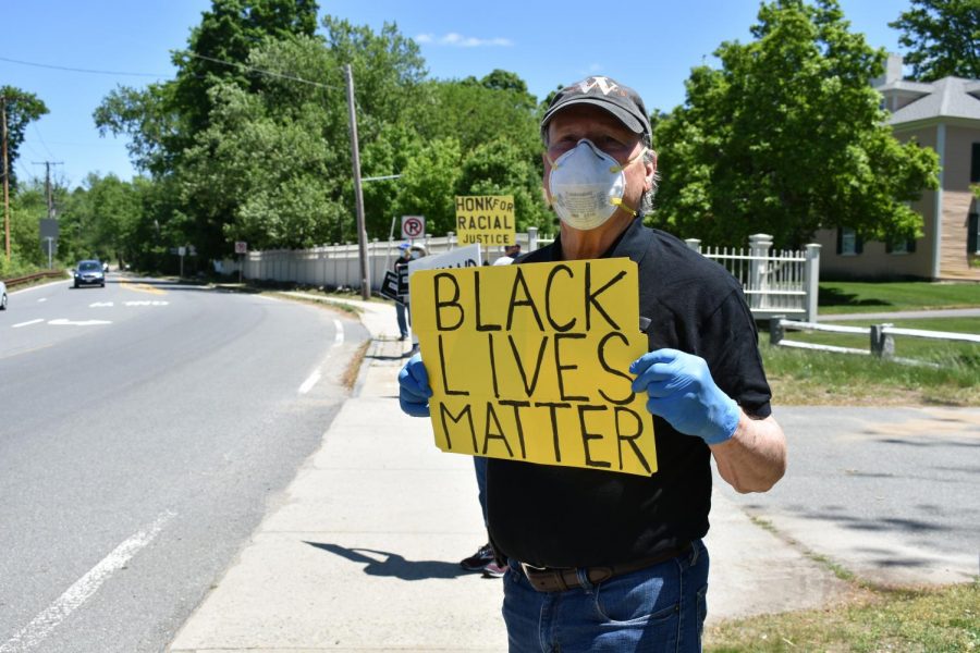 Malcolm Astley holds a Black Lives Matters sign in front of the First Parish Wayland.