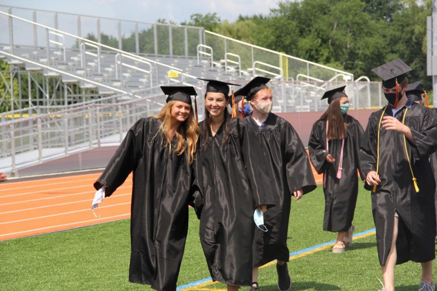 Seniors+Caroline+Lampert+and+Ciara+Murphy+pose+while+leaving+their+graduation.