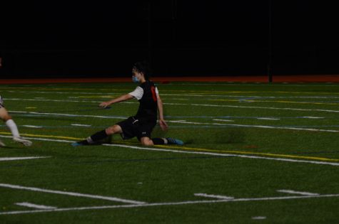 Senior defender Eric Zhang lunges for the ball, as he tries to prevent a scoring chance for Weston. Zhang was pivotal in limiting Weston's scoring opportunities.