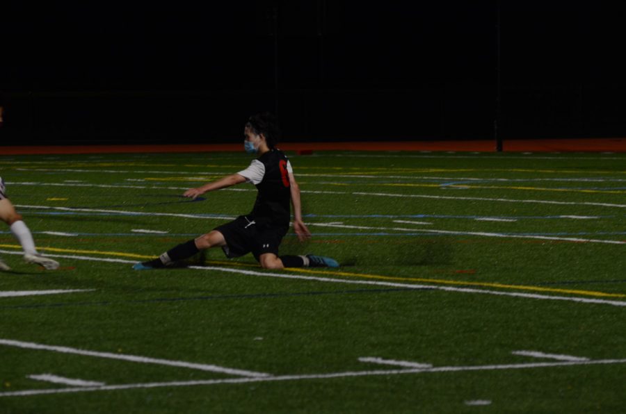 Senior defender Eric Zhang lunges for the ball, as he tries to prevent a scoring chance for Weston. Zhang was pivotal in limiting Westons scoring opportunities.