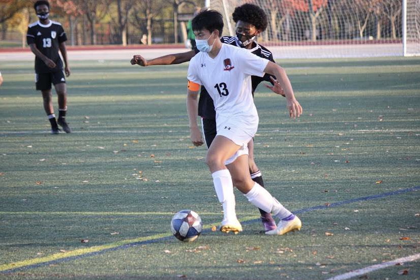 Junior Ben Chen tests the defense as he searches for an opening to advance the ball. Chen was a junior captain for the boys varsity soccer team this year, and will be a captain next year as well. “We can build off of what we had going from this past season since we have a ton of guys returning and a huge senior class,” Chen said.