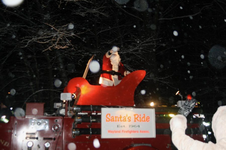 Santa arrives at his stop and waves to the kids below. This photo was taken in 2010 when residents could stand together to see Santa. “We wanted the tradition to continue and wanted to send happiness to people with everything going on,” President of the Wayland Firefighter Association Bob Dorey said.