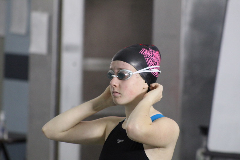 Sophomore Hannah Gordan adjusts her swim cap before she begins her race.