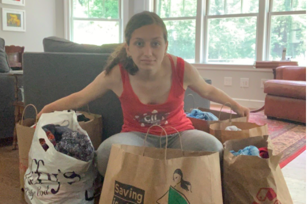 Sophomore Grace Marto poses with her thrifted clothes that she gathered for her non-profit business Clothes for Campers. “I started clothes for campers for the camp I go to, Camp Burgess & Hayward. I'm CITing there for a month this summer, and part of my responsibility is to raise money for camp.”