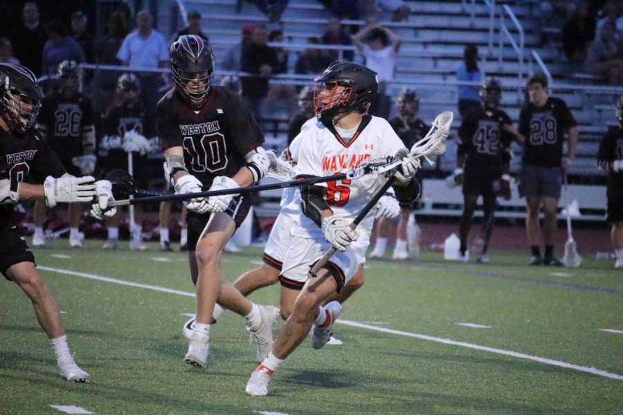 Senior Shane Derubeis looks for a Wayland player in a sea of Weston players to pass to. Westons defense works hard to remove the ball from Derubeiss stick. 