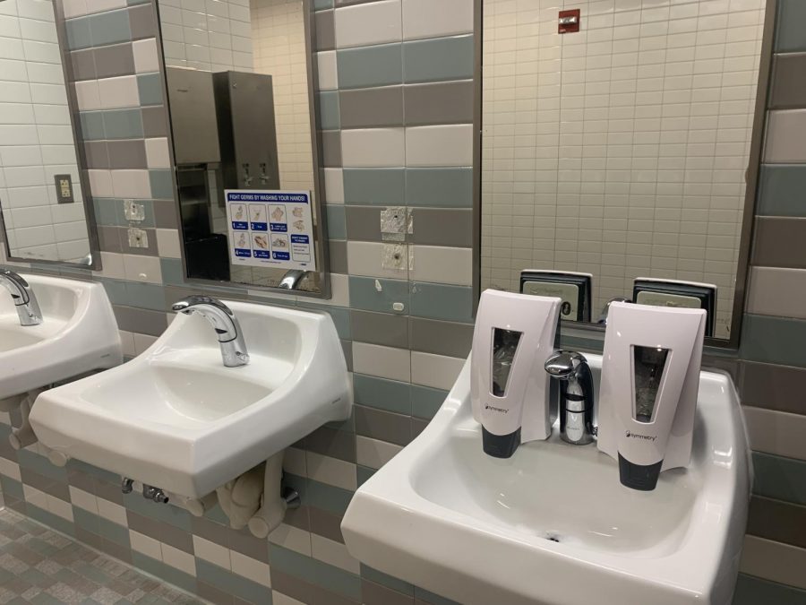 Two soap dispensers rest on the sink after being ripped off from its usual place. 