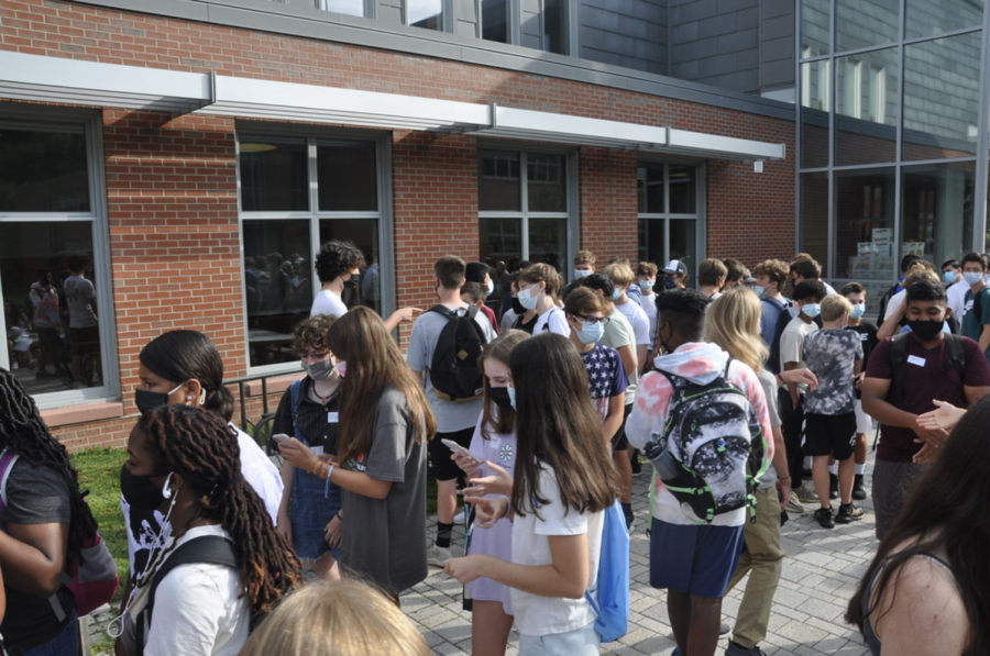 The ninth-graders stand in line as everyone begins to enter the high school building for the start of orientation.
