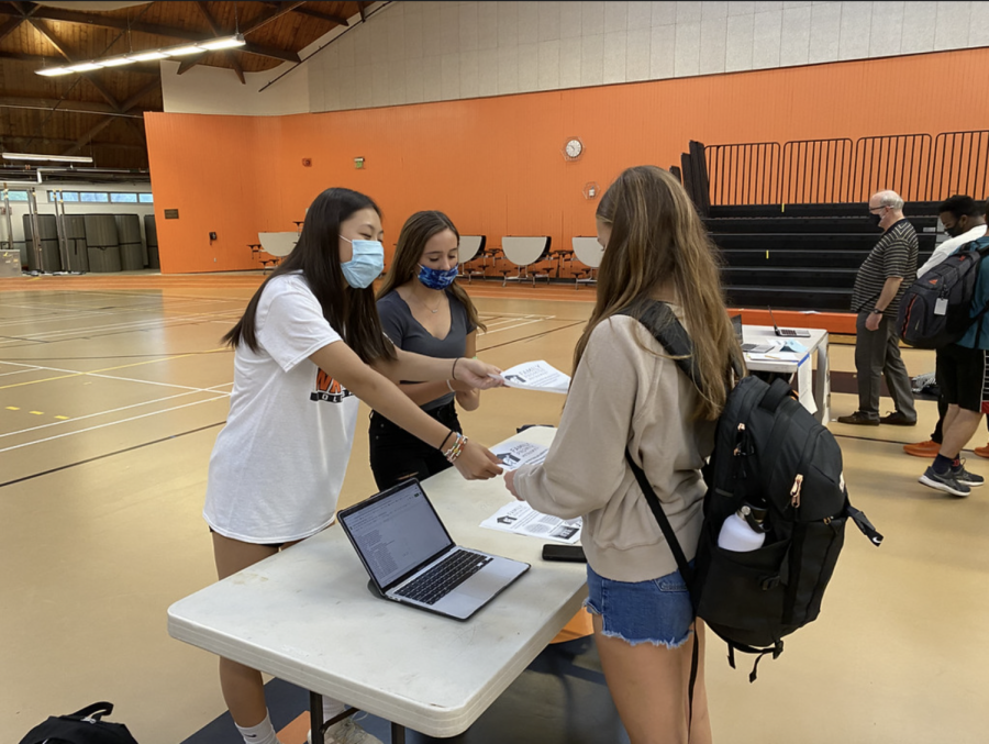 Senior Maeve Myles and Junior Elena Liu lead the Family Promise Club. Standing at their booth, they promote their cause to passing students. The club fair is a great way to get students to want to join our club, and also raise awareness of the homelessness issue, Liu said.
