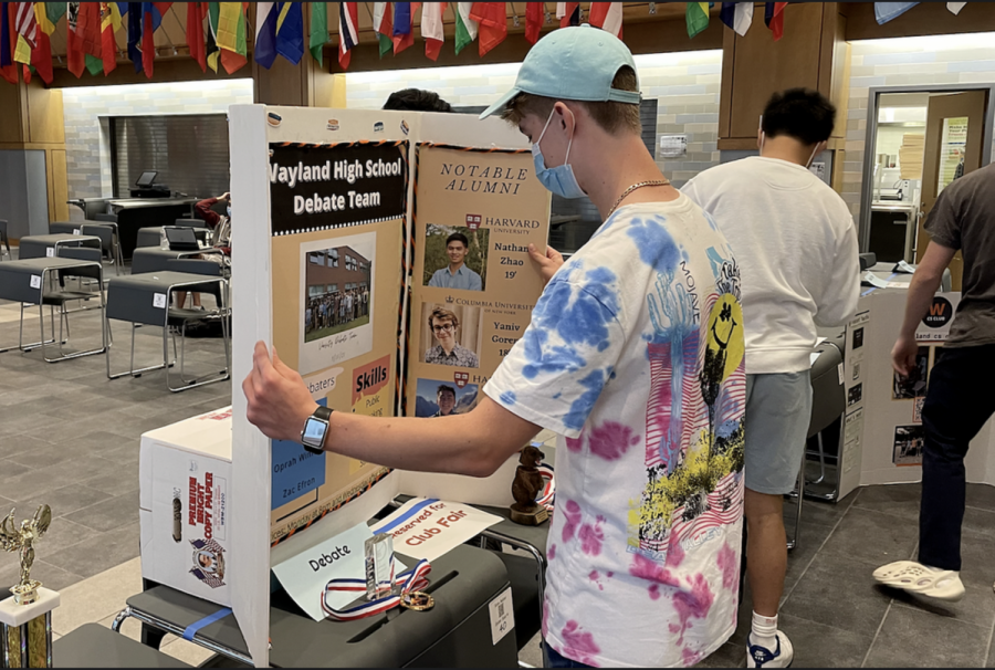 Senior Misha Boyko sets up his WHS Debate Team poster for club fair. Administration allowed students who led clubs to leave class early to prepare. 