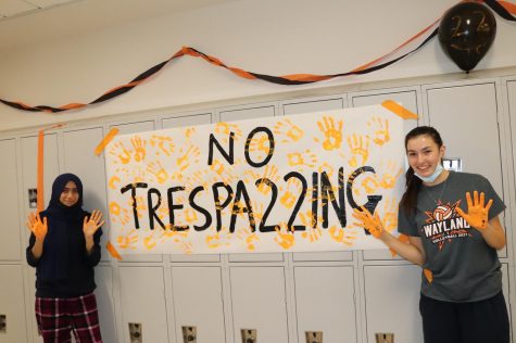Seniors Madeeha Syeda and Marie Popov place orange hand prints on their no trespa22ing sign. The seniors got very creative with incorporating 22 into their signs and posters.