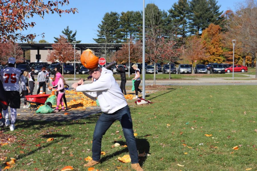 Junior Derek Roberts takes a swing at the half broken pumpkin in hopes of hitting it far.