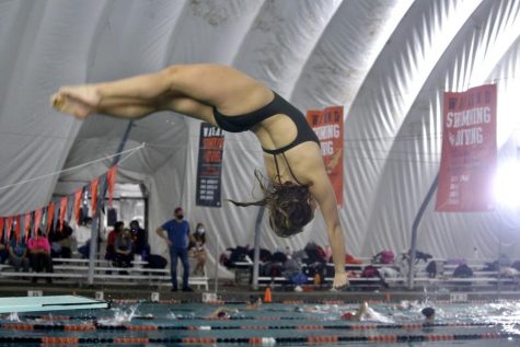 Junior Sophie Stowell executes a twisting dive into the pool. The girls diving team consists of 11 divers, with five returning and six new members.
