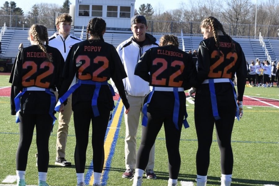 The Class of 2022 senior Powderpuff captains meet at the 50-yard line with senior coaches Finn ODriscoll and Sean Goodfellow. Although it was the last year of Powderpuff, the senior class made memories that will last forever. “We wanted it to be a nice and safe game,” senior Sophie Ellenbogen said. “I was looking forward to playing with the girls in my grade because we haven’t really come together as a group to do a big activity yet.”