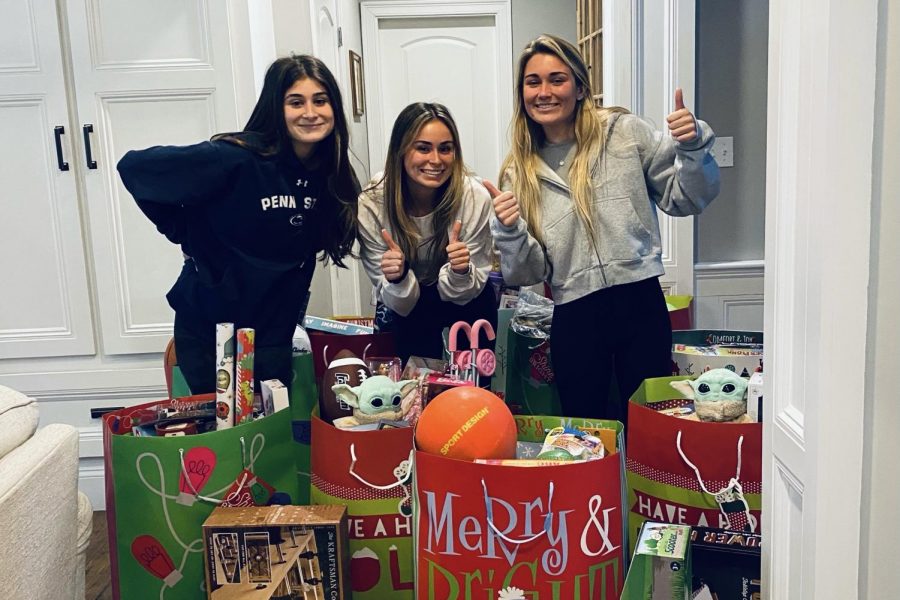 The three Boyajian sisters (left to right), freshman Julianna Boyajian, junior Bella Boyajian and senior Lily Boyajian stand with their gifts they collected for the Department of Children and Families holiday party. The Boyajian family has always had an interest in helping less fortunate children receive gifts when they wake up on Christmas morning. By collecting toys it could allow them to have a normal Christmas if their families arent able to afford any gifts, Lily Boyajian said.