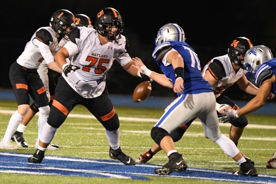 Senior tackle Reid Vanslette blocks a defensive lineman as senior quarterback Adam Goodfellow receives the snap in a game against Danvers. This winter, Vanslette committed to Union College, and Goodfellow committed to Endicott College to further their football careers. With Union, the coaches were the best people that I met, Vanslette said.