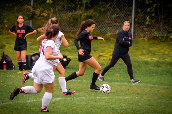 Lisa McNamara runs down the sideline as she coaches her player with the ball. Although McNamara is the new girls varsity soccer coach, she coached last season for the girls JV team. “I expect 100% effort on the field, working hard, respecting the game, coaches and administration,” McNamara said.