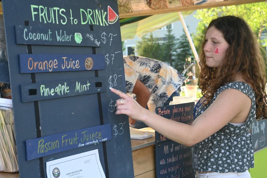 Sophomore Ellie Barenboyem points to the options at the Shabby Gourmet Health Shakes and Smoothies food truck which was a vendor at the event. The Wayland Music Festival was planned several years in advance but suffered a significant delay due to the COVID-19 pandemic.