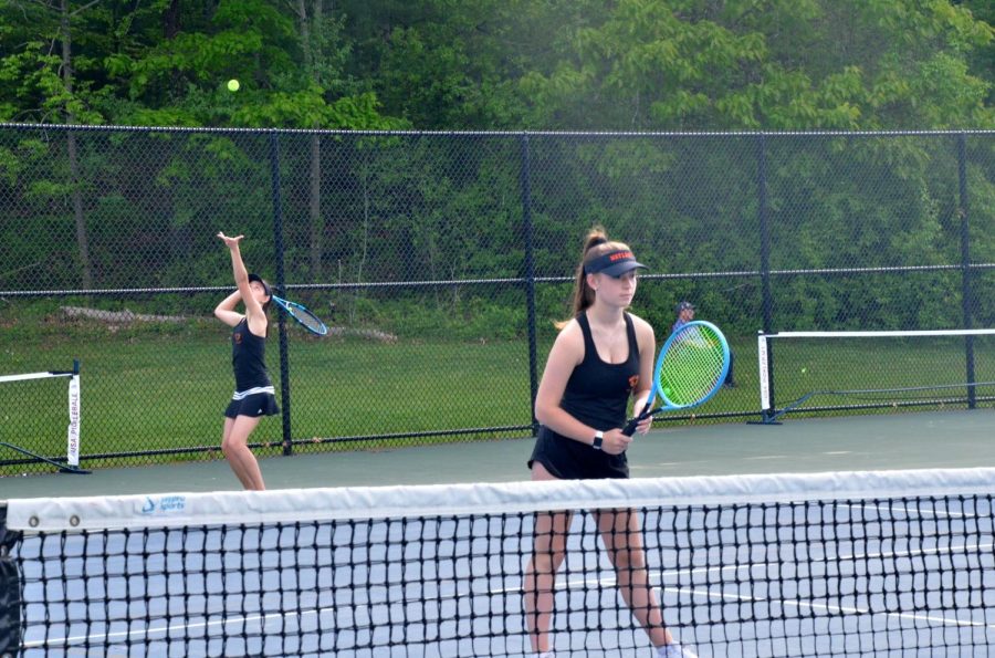 Sophomore Missy Prince stands at the net in ready position while her partner Kally Proctor serves the ball. Being at net means that Prince will more likely hit volleys as opposed to groundstrokes.
