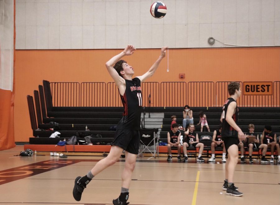 Senior captain Jake Moser braces himself to serve over the net. If a player serves and the ball hits the net, it is counted as a point for the opposing team. 