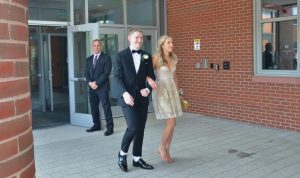 Senior Andrew Boyer and junior Charlotte Richter exit the doors of the North building and walk their way to the orange carpet, showing off their attire.