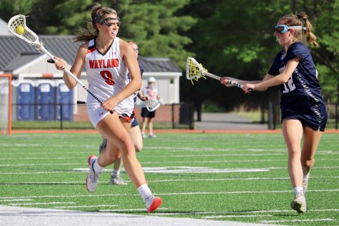 Senior captain Sammy Johnson brings the ball down the field into Waylands half, looking for an open pass. Not only is Johnson a captain of the lacrosse team, but she was also a basketball captain in the winter.