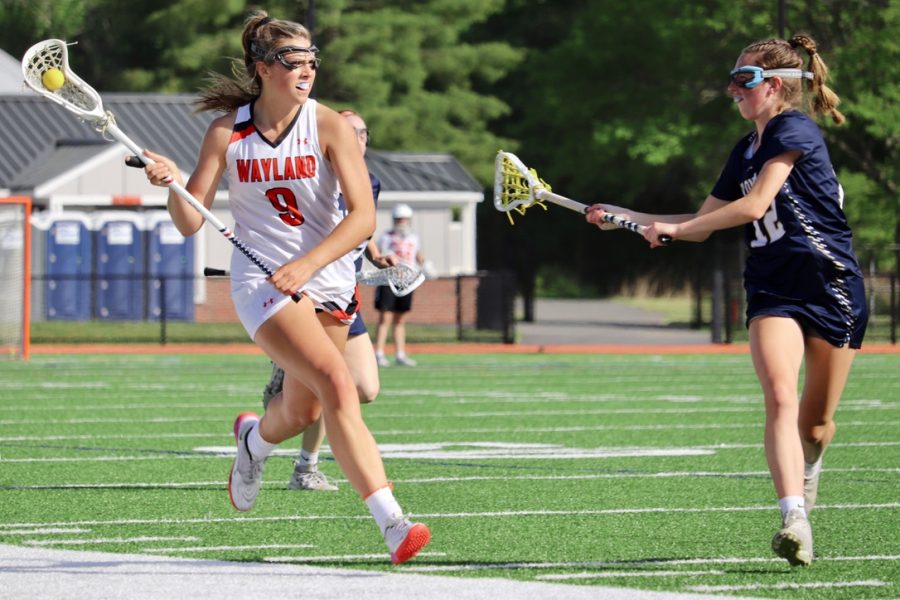 Senior captain Sammy Johnson brings the ball down the field into Waylands half, looking for an open pass. Not only is Johnson a captain of the lacrosse team, but she was also a basketball captain in the winter.