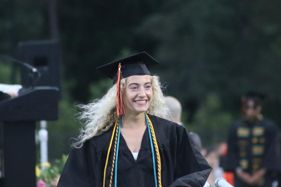 Senior Emily Staiti walks down the ramp from the podium after receiving her diploma. The graduates were given their diplomas based on the alphabetical order of their last name.