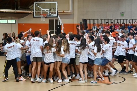 The seniors run into a mob, cheering to the music. For the first time since 2019, the field house held the first-day assembly. Due to COVID-19, the tradition took place outside on the turf last year.