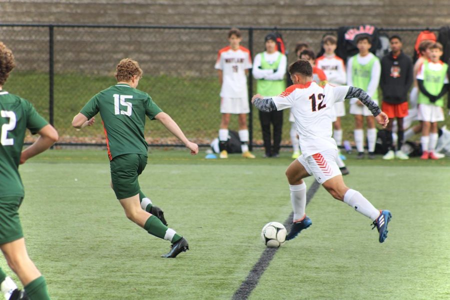 Junior Xande Santos dribbles the ball down the field while a Hopkinton player tries to defend against him. I believe the squad this year was very talented, and everyone had good chemistry, Santos said. We did a lot better than expected, so I was happy with how far we went.