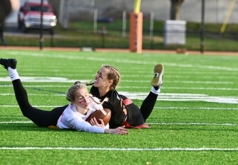 Senior Charlotte Richter pulls her opponents flag off, causing both of them to fall down. Due to the injuries in the past powderpuff games, new playing rules were put into place to ensure that the game ran safely and smoothly.