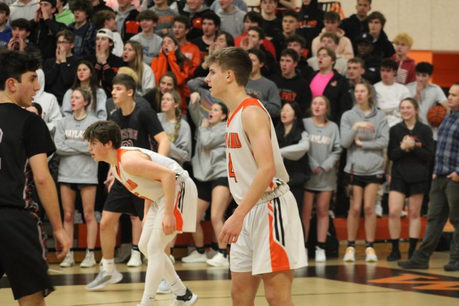 Senior Eric Hiebert guards his man during a Wayland defensive play while the fan section cheers behind him. I wasnt expecting that many people in the crowd there on senior night, Hiebert said. It was really exciting to see all the people come out. Weve had a bit of a tough start to the season, and then more recently we started winning games, so senior night was kind of like a culmination of all the hard work that weve been working for the entire season.
